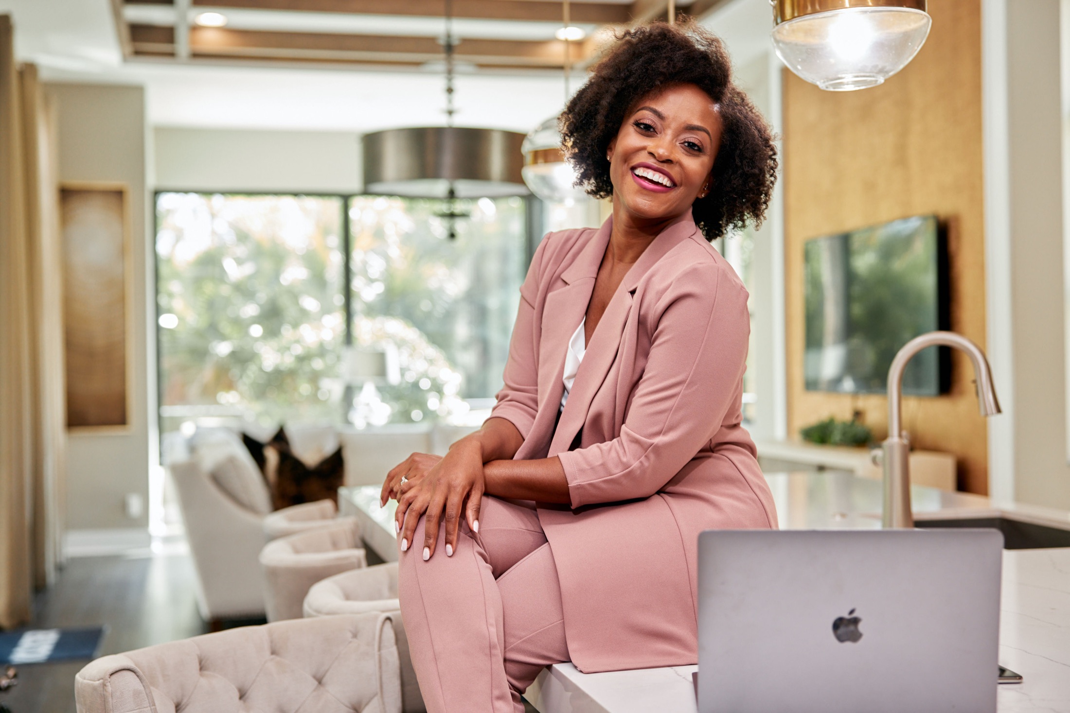 Tiffany Nwahiri standing beside her laptop